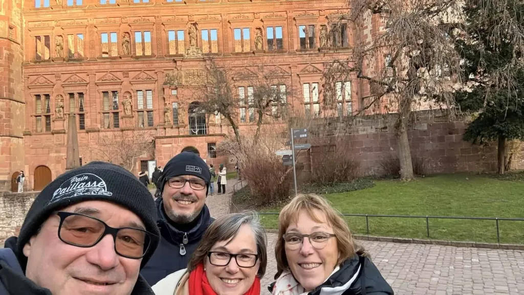 Alttag: Gruppe von Menschen vor historischem roten Gebäude in Heidelberg, Deutschland.