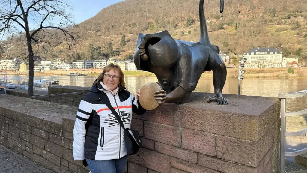 Groeßer Mensch neben Skulptur des Löwen mit Ball am Rheinufer in Koblenz.