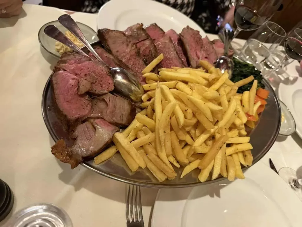 Hackbraten mit Pommes und Gemüse, köstliches Gericht, perfekt serviert in elegantem Restaurantstil.