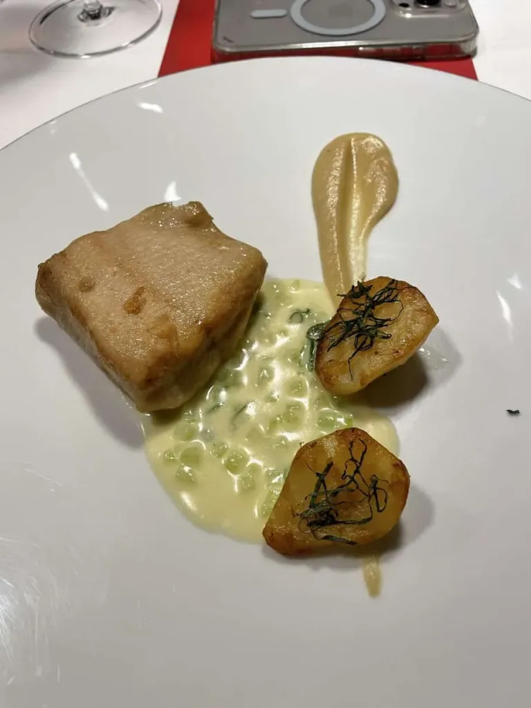 Zartes Fischfilet mit Sauce und Kartoffel-Tapas, gourmet Küche, feines Essen, hochwertiges Gericht, elegante Präsentation.