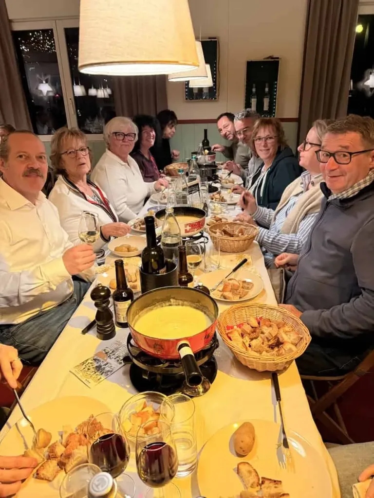 Gemütliche Familienfeier mit Freunden beim Abendessen in einem Restaurant, mit köstlichen regionalen Speisen und Wein.
