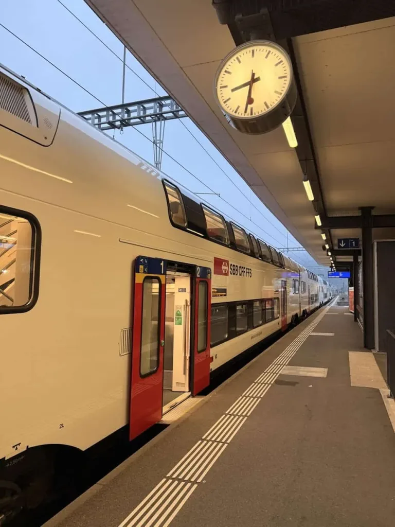 SBB Doppelstockzug im Zürcher Bahnhof bei Sonnenaufgang, moderne Rail-Infrastruktur.