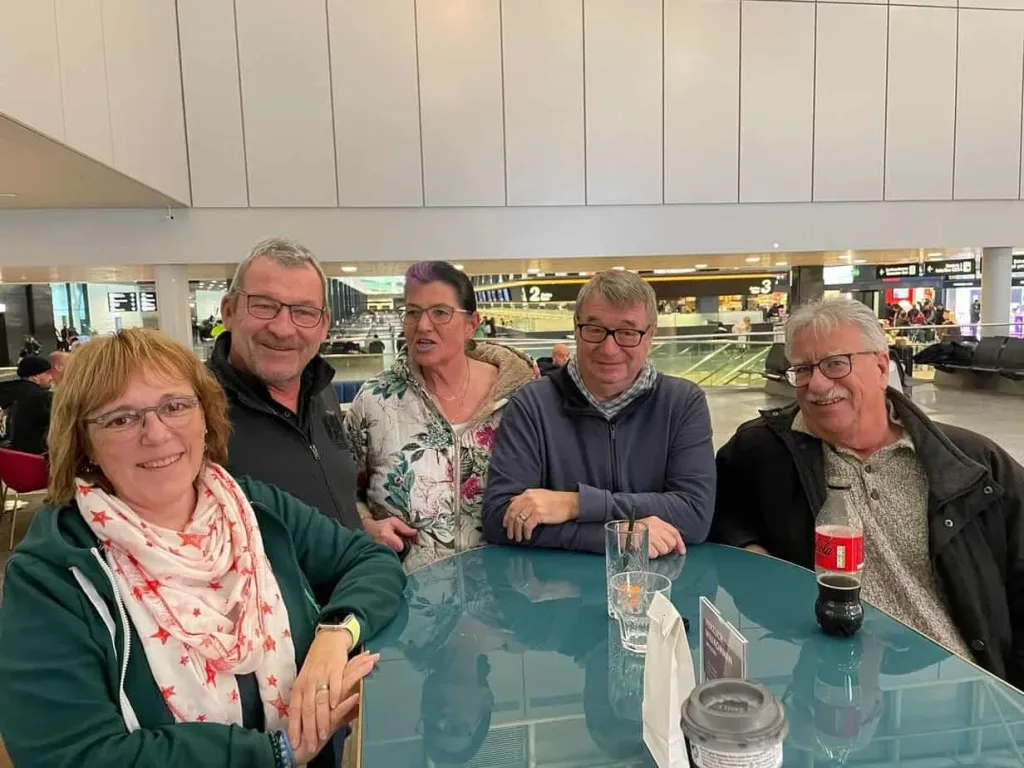 Menschen im Flughafen warten am Tisch, entspanntes Gepäck, Reise, Flughafen, Gemeinschaft, Kaffee, Getränke, Flugreise, Reisegruppe.