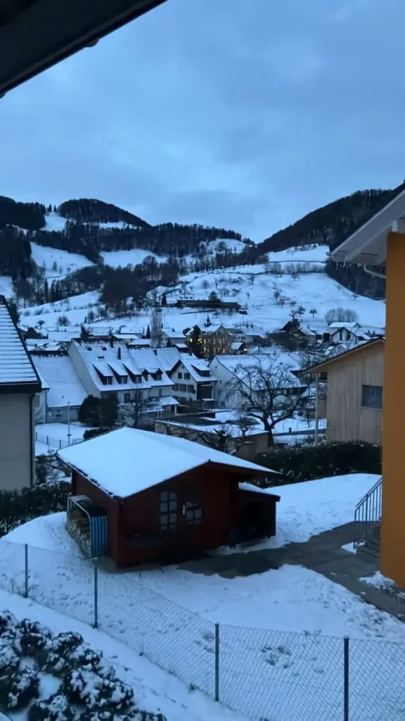 Schneebedeckte Berge und Dorf in der Schweiz bei winterlicher Stimmung.